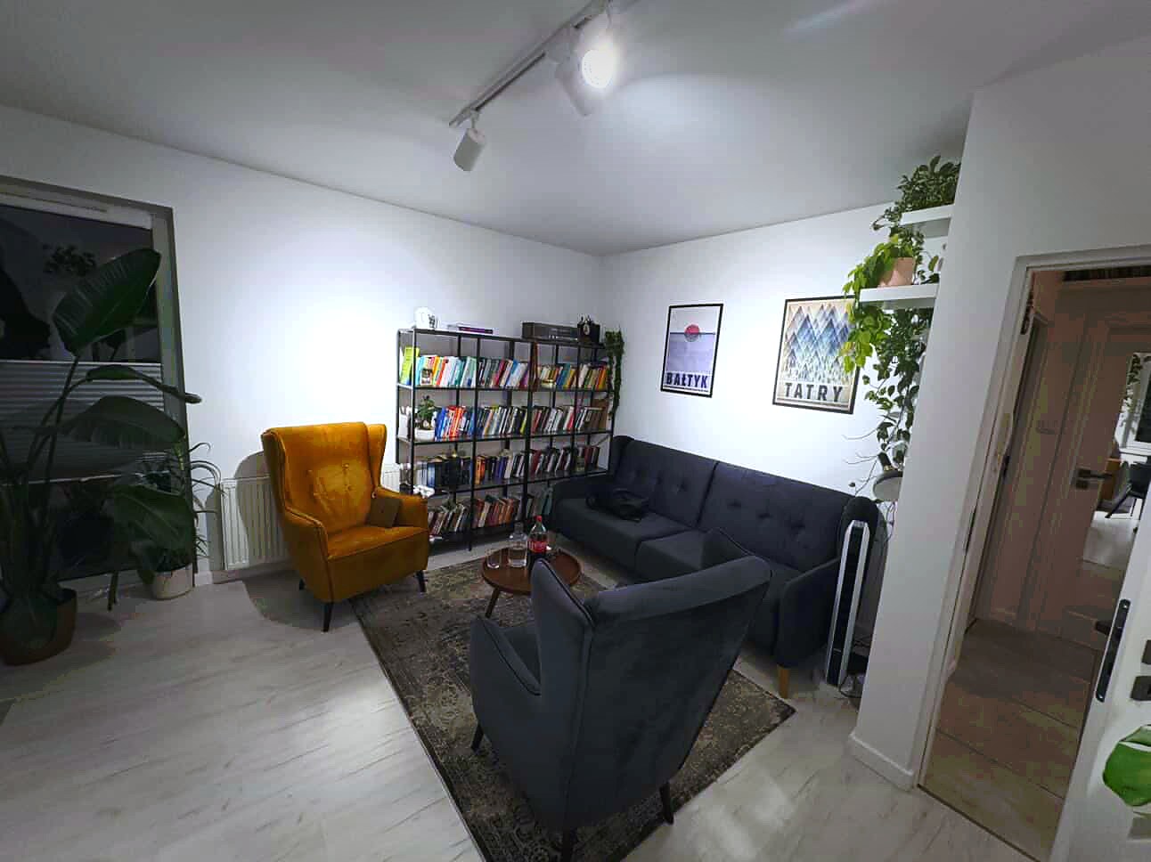 Sala grupowa z regałem z książkami i żółtym fotelem — gabinet Centrum Psychoterapii Gdańsk